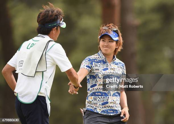 Misuzu Narita of Japan shakes hands with her caddie on the 18th green during the final round of the World Ladies Championship Salonpas Cup at the...