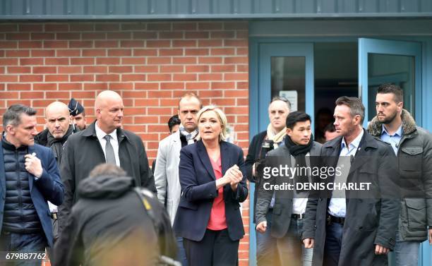 French presidential election candidate for the far-right Front National party Marine Le Pen escorted by her bodyguard Thierry Legier gestures as she...
