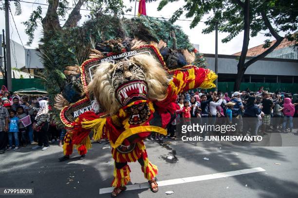 Dancers perform the traditional Reog Ponorogo dance during a street parade in Surabaya on May 7, 2017. The parade is part of celebrations to mark the...