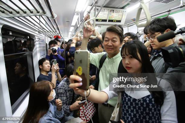 South Korean presidential candidate Ahn Cheol-Soo of the People's Party takes a selfie with his supporters during his street election campaign on May...