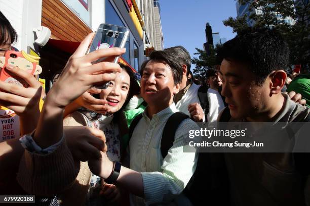 South Korean presidential candidate Ahn Cheol-Soo of the People's Party takes a selfie with his supporters during his street election campaign on May...