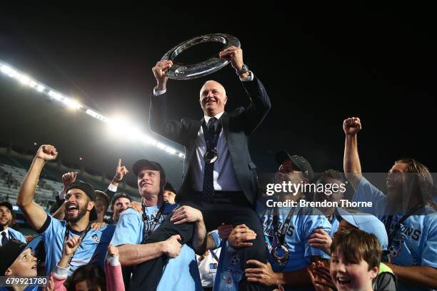 Sydney FC coach, Graham Arnold is hoisted up by players with the A-League trophy in front of fans following the 2017 A-League Grand Final match...