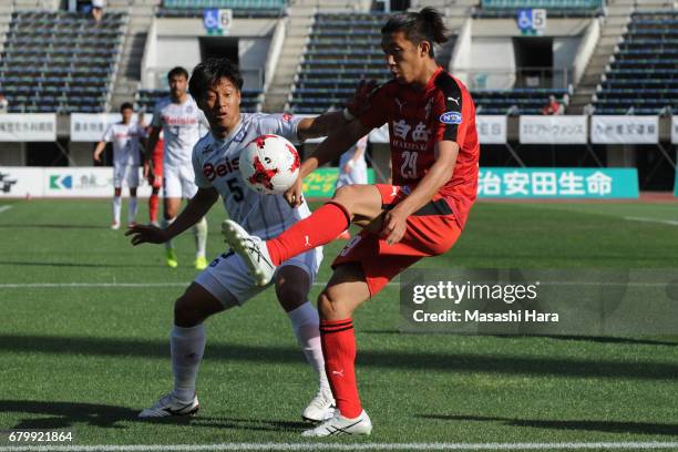 Keita Saito of Roasso Kumamoto and Takumi Abe of Thespa Kusatsu Gunma compete for the ball during the J.League J2 match between Roasso Kumamoto and...
