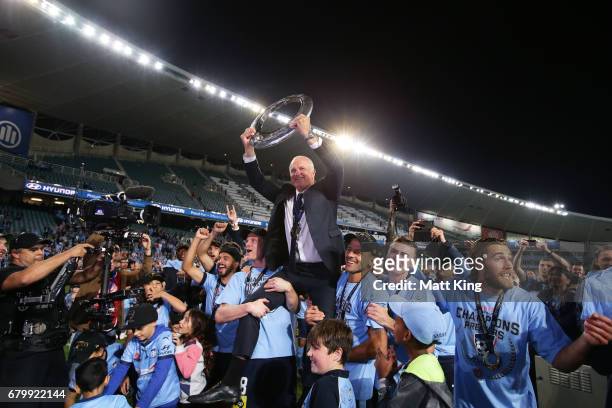 Sydney FC coach Graham Arnold is lifted by players and holds aloft the A-League trophy in front of The Cove after the 2017 A-League Grand Final match...