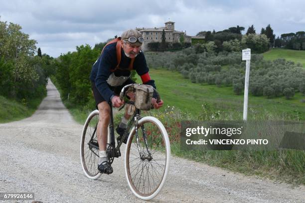 Italian Luciano Berruti rides his old bike on the white roads of Tuscany during the "Eroica Montalcino" festive event on May 7, 2017 near Montalcino....