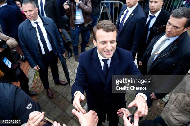 French presidential election candidate for the 'En Marche!' political movement, Emmanuel Macron meets his supporters as he leaves the polling station...