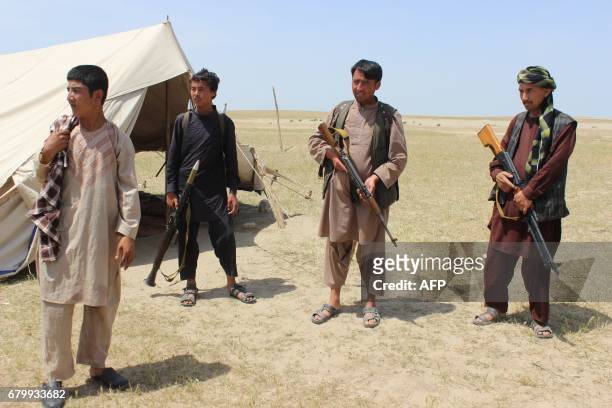 Members of an Afghan militia look on during fighting between Taliban militants and Afghan security forces near the Qala-e-Zal district in Kunduz...