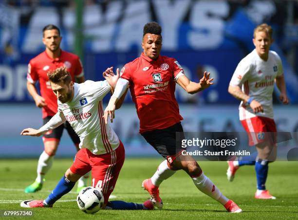 Aaron Hunt of Hamburg is challenged by Jean-Philippe Gbamin of Mainz during the Bundesliga match between Hamburger SV and 1. FSV Mainz 05 at...