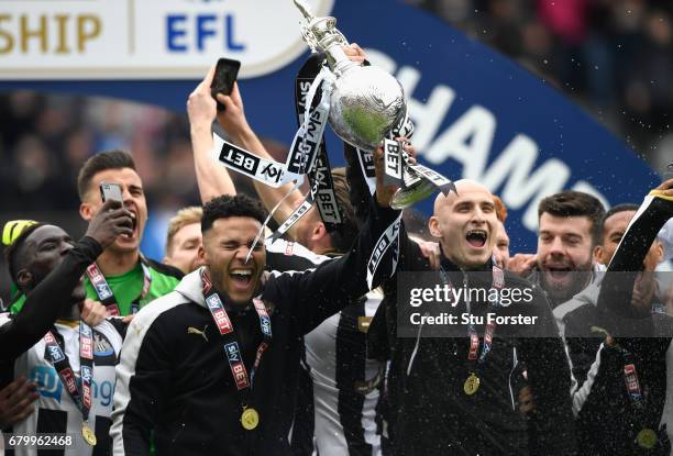 Newcastle United players Jaamal Laschelles and Jonjo Shelvey lift the trophy after winning the Sky Bet Championship match between Newcastle United...