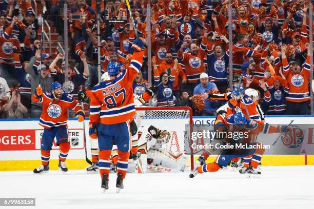 Drake Caggiula celebrates his goal with teammates Patrick Maroon, Connor McDavid and Jordan Eberle of the Edmonton Oilers as goalie John Gibson of...