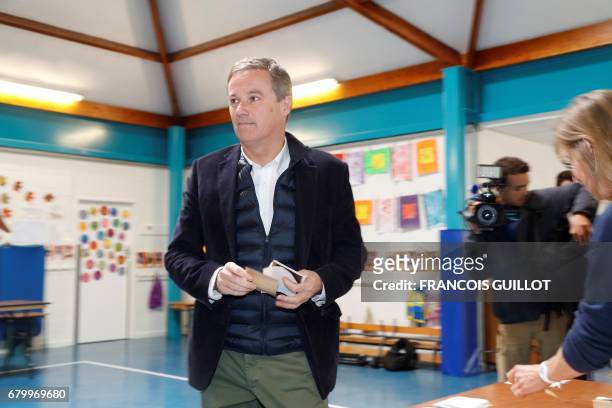 Former French presidential election candidate for the right-wing Debout la France party Nicolas Dupont-Aignan prepares to vote at a polling station...