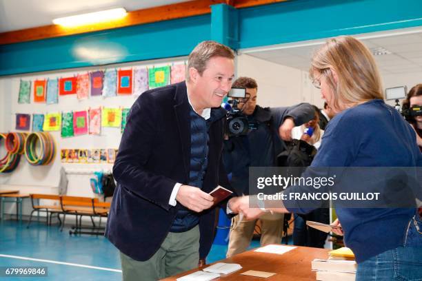 Former French presidential election candidate for the right-wing Debout la France party Nicolas Dupont-Aignan prepares to vote at a polling station...