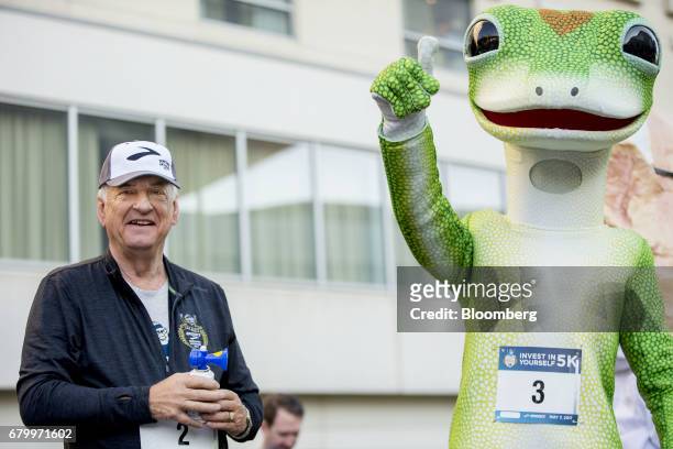 Tony Nicely, chief executive officer of the Government Employees Insurance Co. , stands with the GEICO gecko mascot after signaling the start of the...