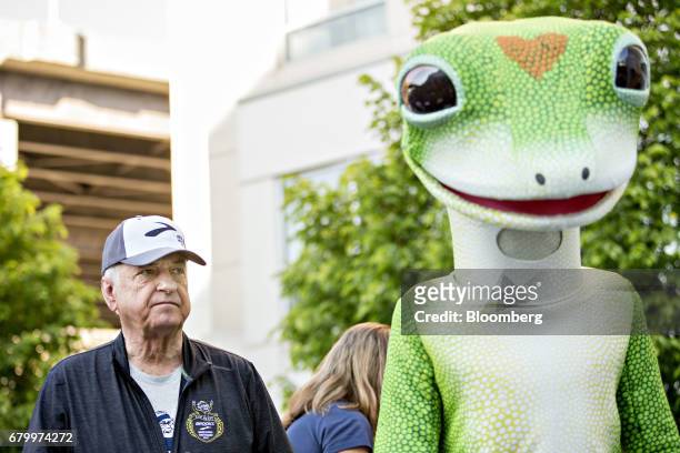 Tony Nicely, chief executive officer of the Government Employees Insurance Co. , stands with the GEICO gecko mascot before signaling the start of the...