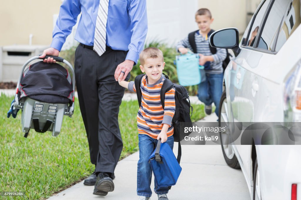 Businessman with baby taking sons to school