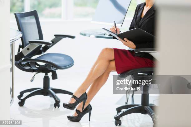 cropped view of businesswoman in office taking notes - crossed legs heels stock pictures, royalty-free photos & images