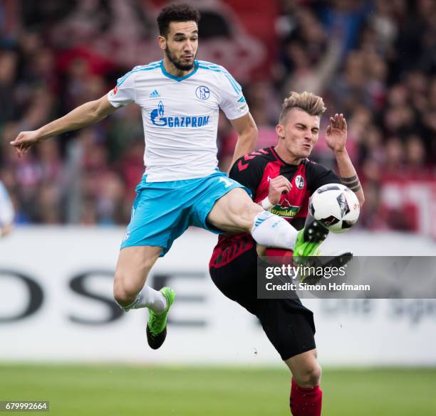 Nabil Bentaleb of Schalke is challenged by Maximilian Philipp of Freiburg during the Bundesliga match between SC Freiburg and FC Schalke 04 at...