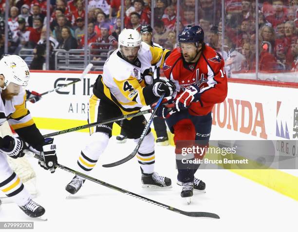 Justin Williams of the Washington Capitals is checked by Justin Schultz of the Pittsburgh Penguins in Game Five of the Eastern Conference Second...