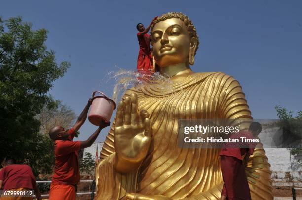Buddhist monks cleaning and washing Buddha idol ahead of Buddha Purnima at Maitrayi Vihar, on May 7, 2017 in Bhopal, India. Buddha Purnima marks the...