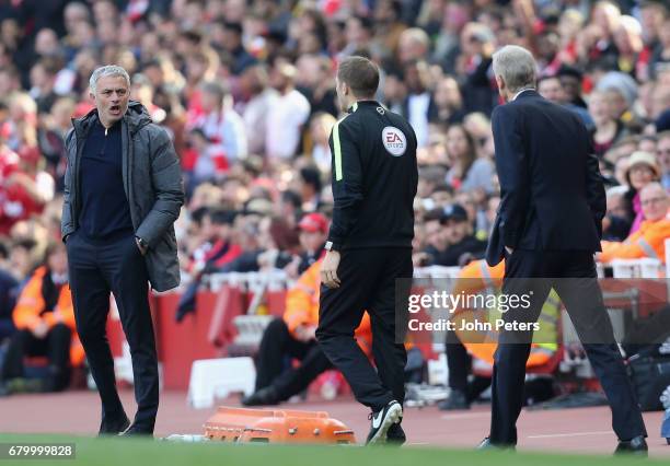 Manager Jose Mourinho of Manchester United and Manager Arsene Wenger of Arsenal speak to the fourth official during the Premier League match between...