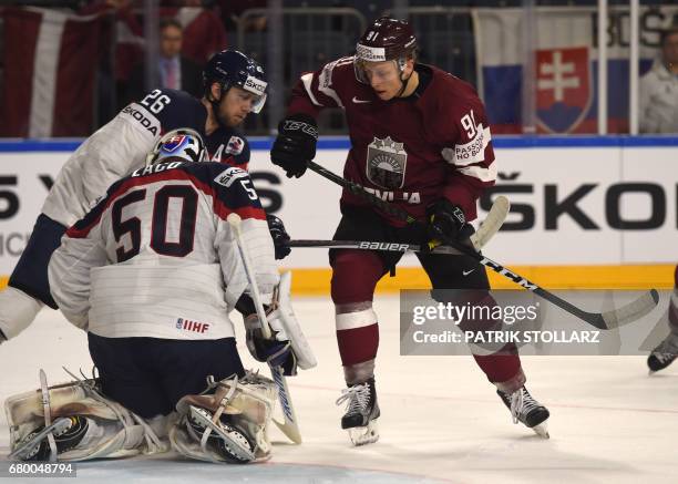 Latvia�´s Maris Bicevskis, Slovakia´s Jan Laco and Slovakia´s Juraj Mikus vie for the puck during IIHF Icehockey world championship first round match...