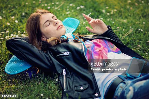 adolescente está deitada e fumando cigarro - girl smoking - fotografias e filmes do acervo
