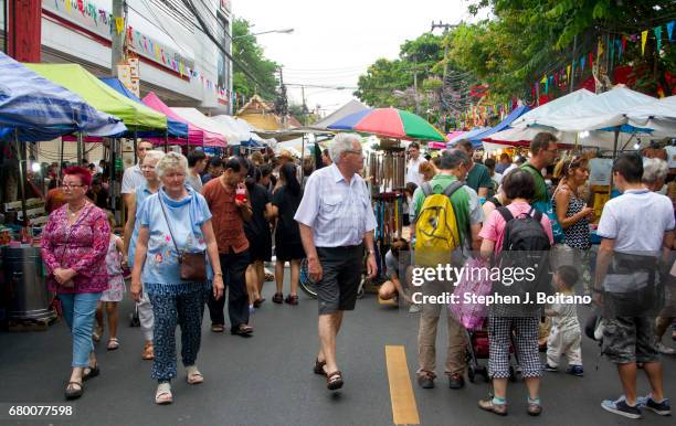 People walk through and shop at the Sunday Night Market on Rachadamnoen Rd in Chiang Mai, Thailand.