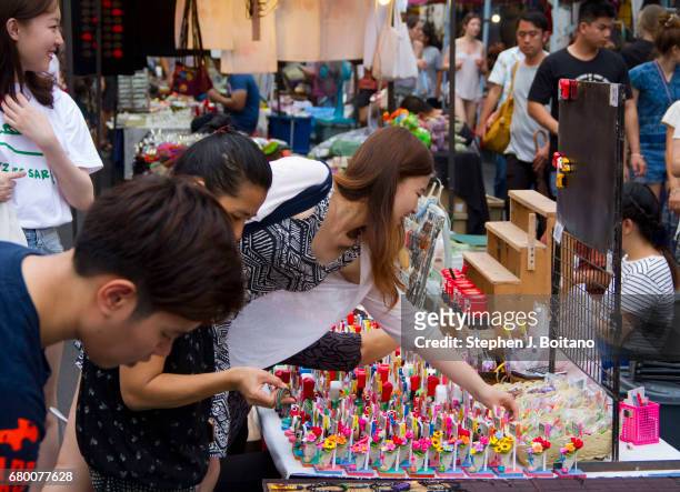 People walk through and shop at the Sunday Night Market on Rachadamnoen Rd in Chiang Mai, Thailand.