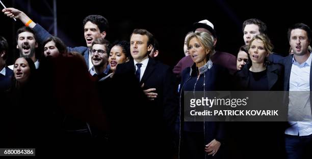 French president-elect Emmanuel Macron and his wife Brigitte Trogneux sing the national anthem in front of the Pyramid at the Louvre Museum in Paris...