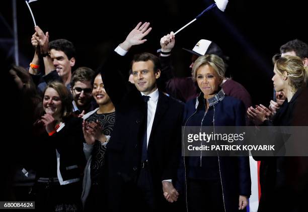 French president-elect Emmanuel Macron and his wife Brigitte Trogneux wave to the crowd in front of the Pyramid at the Louvre Museum in Paris on May...