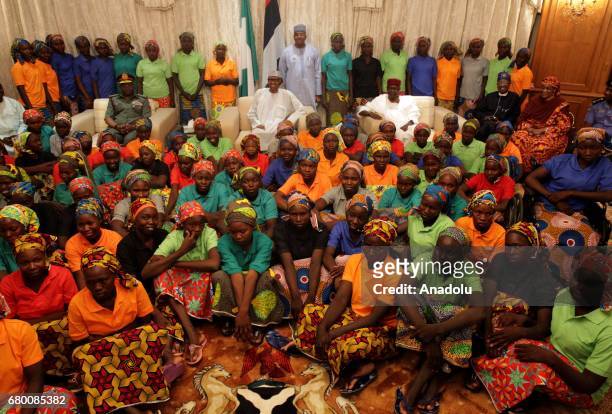 President of Nigeria Muhammadu Buhari poses for a photo with the relatives of abducted girls after the releasing 82 of school girls, kidnapped by...