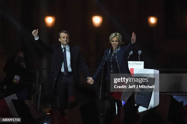 Leader of 'En Marche !' Emmanuel Macron and his wife Brigitte wave to supporters after winning the French Presidential Election, at The Louvre on May...