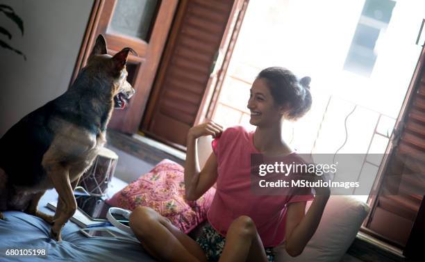 two friends at home having fun. - smiling brown dog stock pictures, royalty-free photos & images