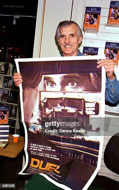 Actor Dennis Weaver holds up a "Duel" poster a film in which he starred during the signing of his new book "All The World's A Stage" at Brentanos...