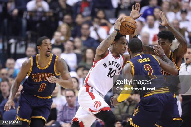 Toronto Raptors guard DeMar DeRozan looks for space between Kyrie Irving and Iman Shumpert as the Toronto Raptors lose the Cleveland Cavaliers in...