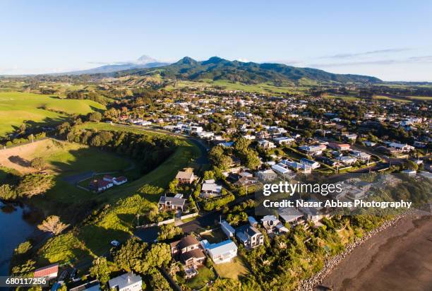 oakura small town with the backdrop of mt taranaki, new zealand. - new zealand beach house stock pictures, royalty-free photos & images