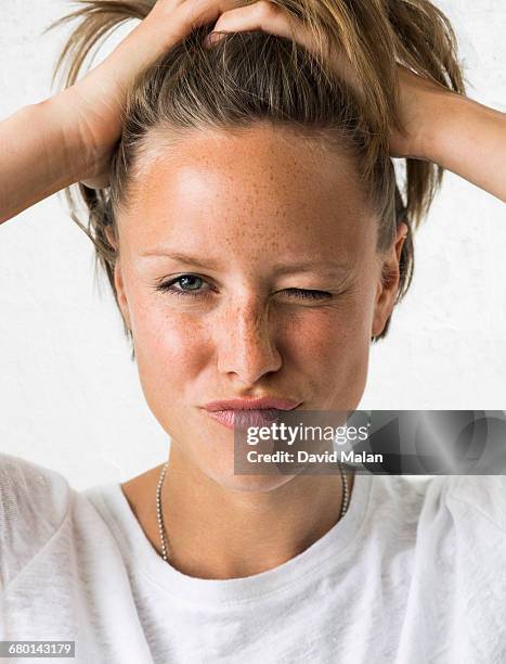 blonde woman holding her hair & winking - winking stock pictures, royalty-free photos & images