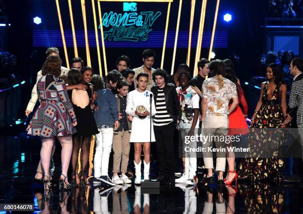 The cast of 'Stranger Things' accepts Show of the Year from the cast of '13 Reasons Why' onstage during the 2017 MTV Movie And TV Awards at The...