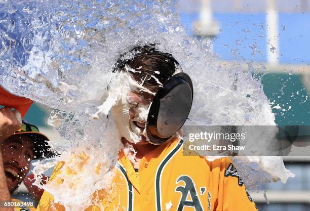 Ryon Healy of the Oakland Athletics is covered in water by Adam Rosales after he hit a walk-off home run in the ninth inning against the Detroit...