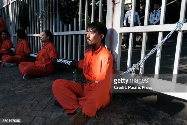 Activists from Greenpeace Philippines chained themselves to the gates of the Department of Environment and Natural Resources in Quezon City, to...
