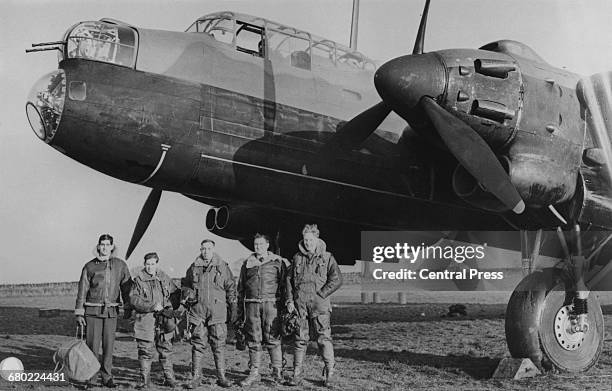 The flight crew of an Avro Manchester Mk 1A of No.207 Squadron Royal Air Force Bomber Command line up beneath the aircrafts forward section showing...
