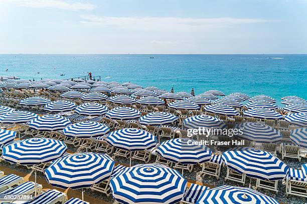 beach parasols, nice, cote d'azur, france - parasols stockfoto's en -beelden