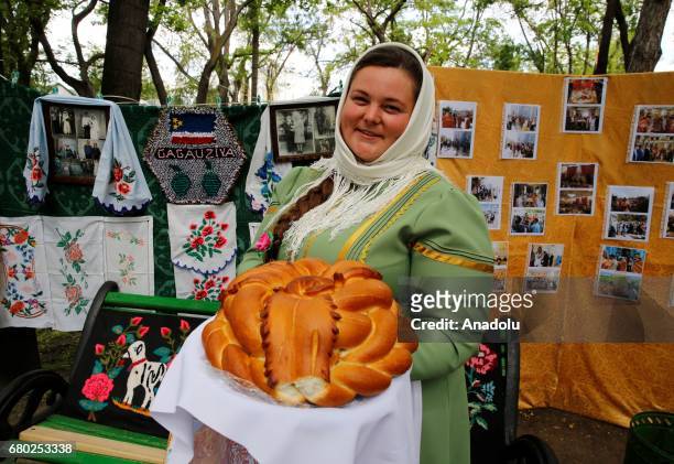 Gokoguz Christian Turk woman, wearing traditional clothes, shows a bread during the Hidirellez celebrations at Stefan Cel Mare Central Park in...