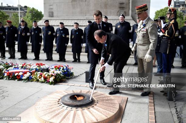 Outgoing French president Francois Hollande renews the eternal flame as French president-elect Emmanuel Macron and President of the Committee of the...