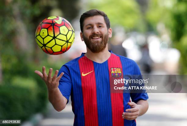 Reza Parastesh, a doppelganger of Barcelona and Argentina's footballer Lionel Messi, poses for a picture in a street in Tehran on May 8, 2017. / AFP...