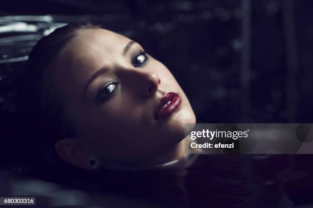 beautiful woman in black water - low key imagens e fotografias de stock