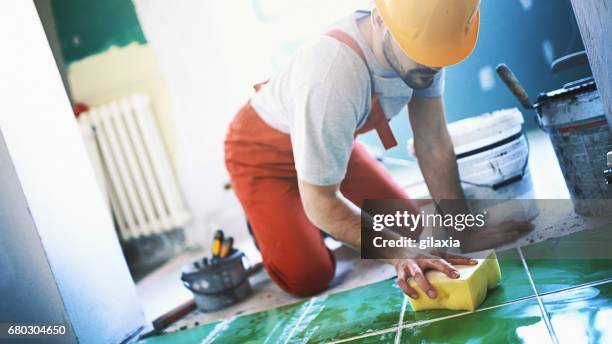 handyman installing ceramic tiles. - interior finishing stock pictures, royalty-free photos & images