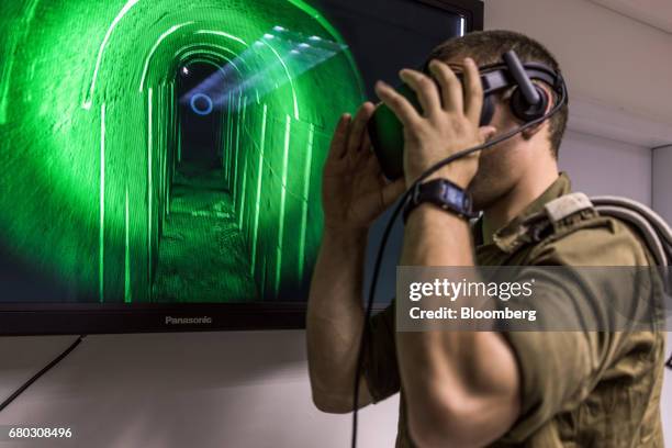 An Israeli special combat soldier adjusts a VR headset during a training exercise using virtual reality battlefield technology to simulate Hamas...