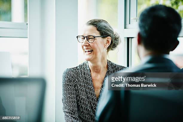 laughing mature businesswoman in team meeting - senior executives bildbanksfoton och bilder