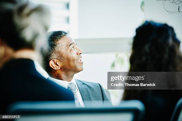 smiling businessman leading team meeting - business woman looking up stock pictures, royalty-free photos & images